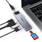 Hub Choetech HUB-M24 gris espacial junto a una MacBook, con cables Ethernet, HDMI, USB y tarjetas SD